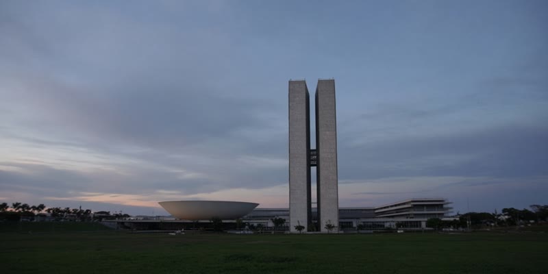 Twin congressional towers at dusk across a lawn, no readable signs.